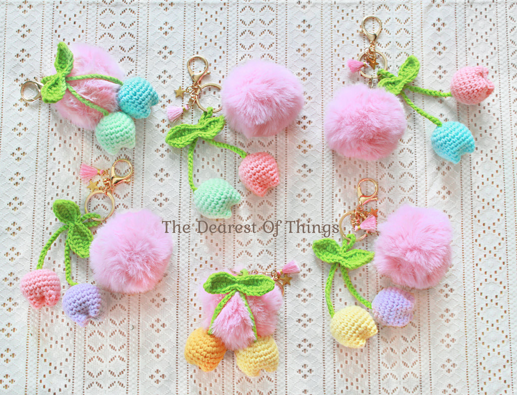 Pastel-colored crochet tulip keychains with a pink pompom
