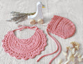 Pink colored lace baby bib and bonnet set